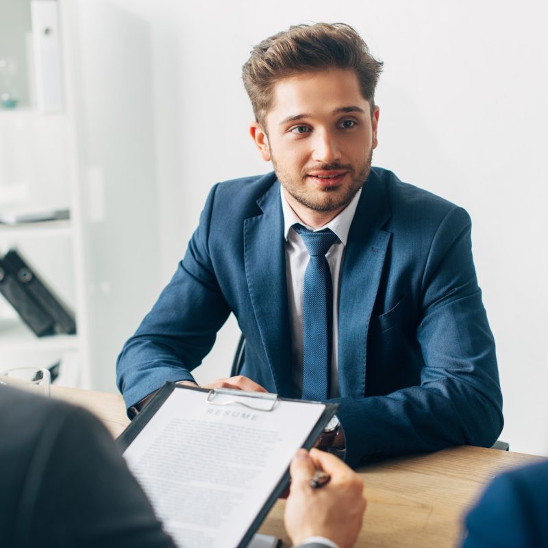 selective-focus-of-handsome-employee-looking-at-recruiter-during-job-interview.jpg
